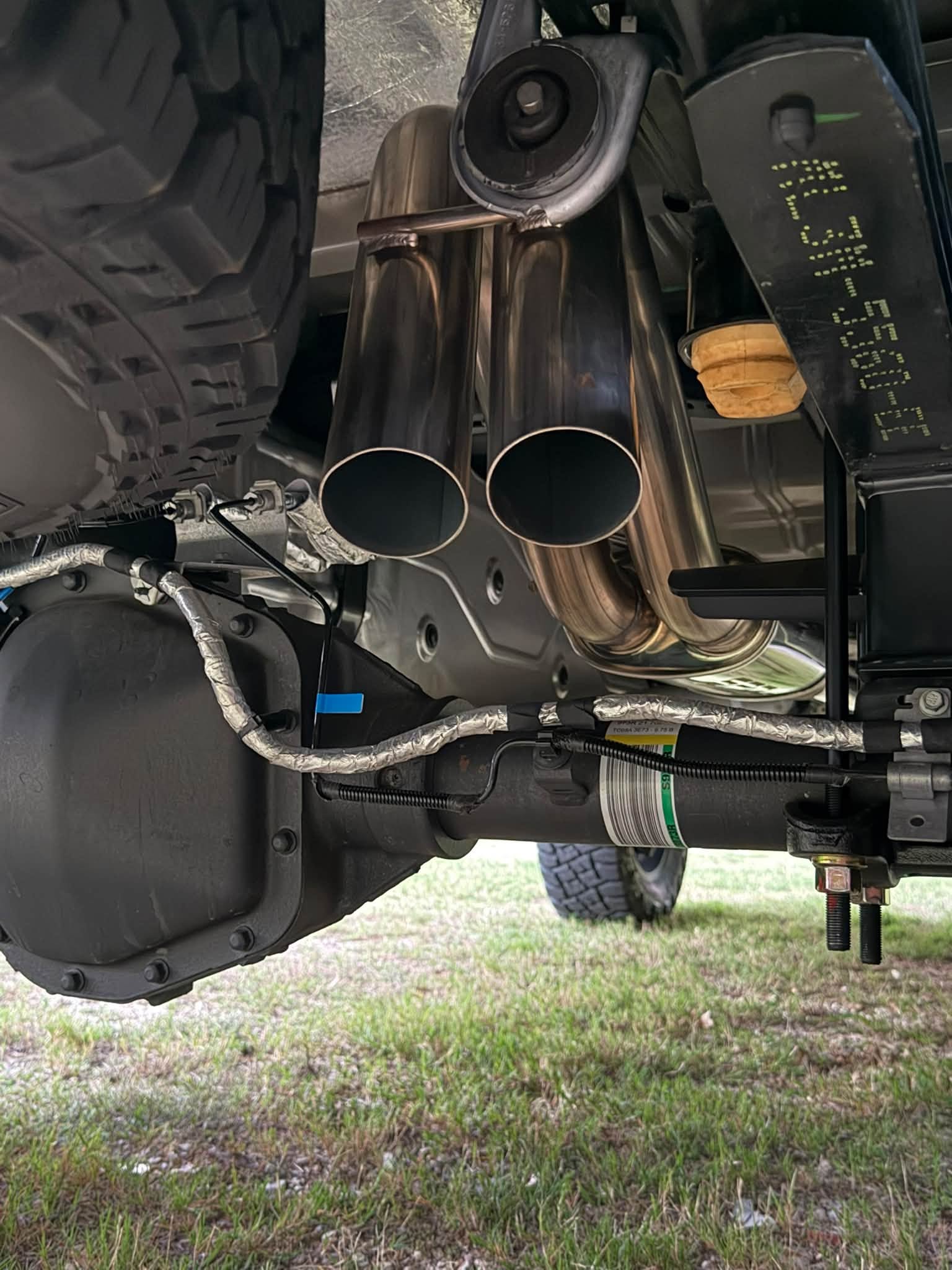 Undercarriage detail showing the axle-dump exhaust and Falcon rear shock.